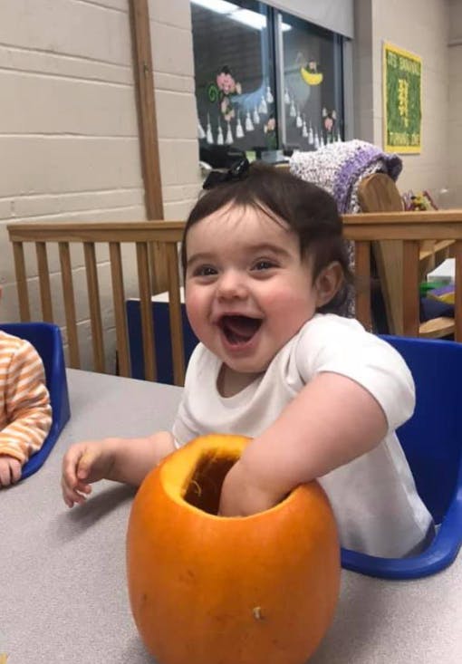 Child with hand inside a pumpkin