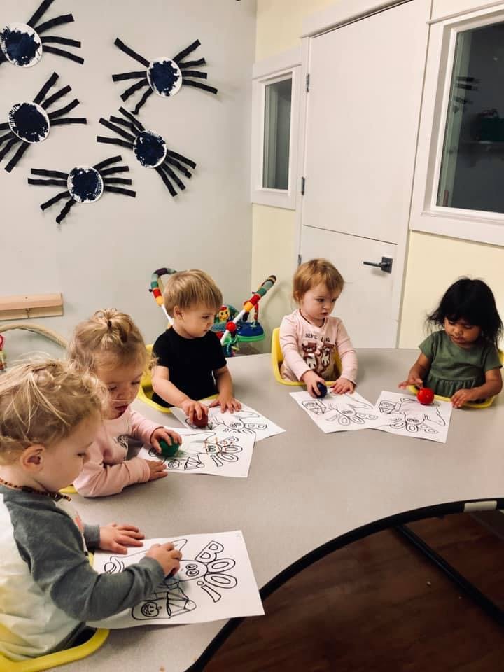 Children coloring at a table in a classroom