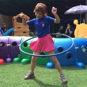 Child hula hooping outdoors