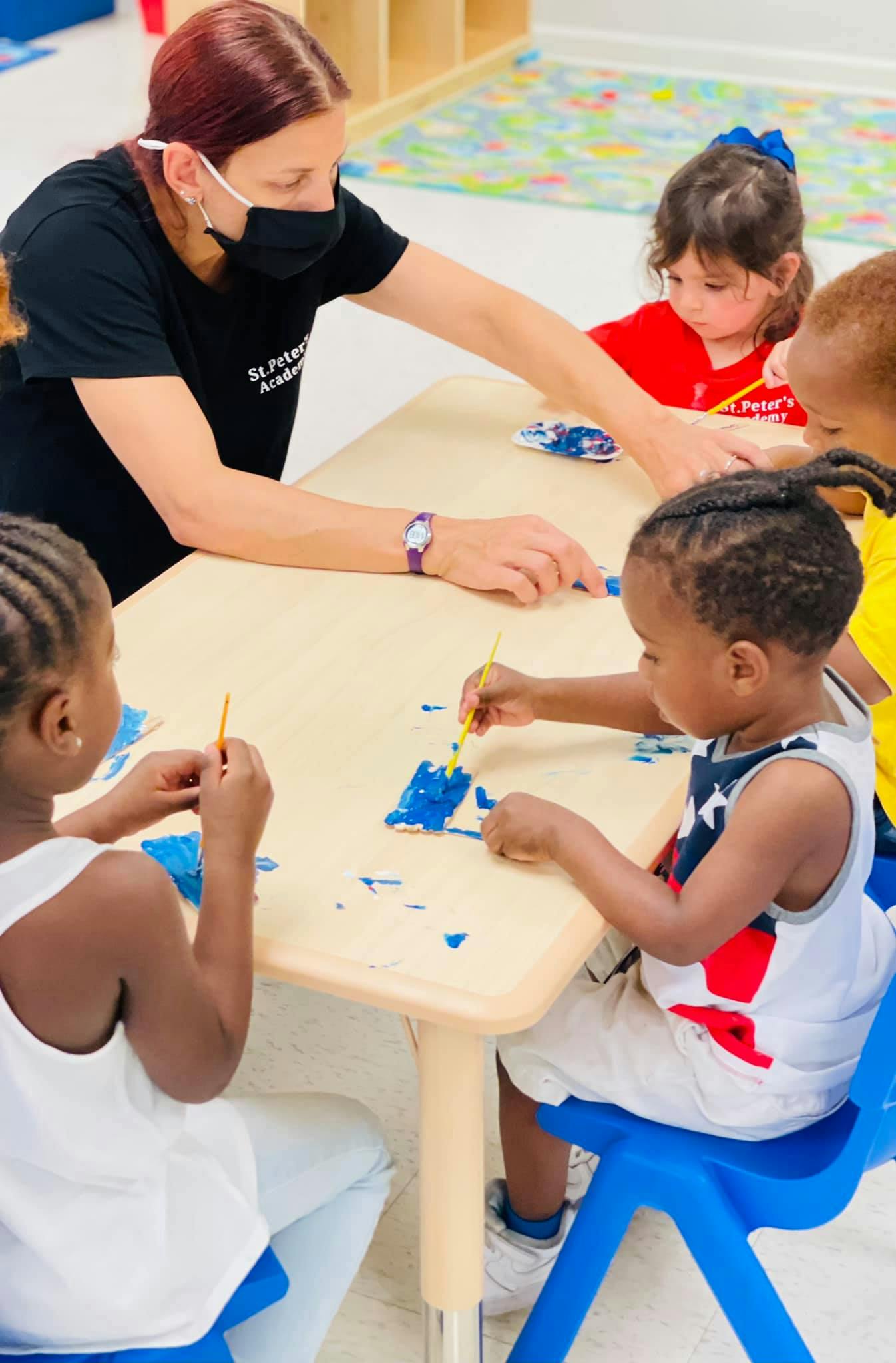 Adult and children painting at a table