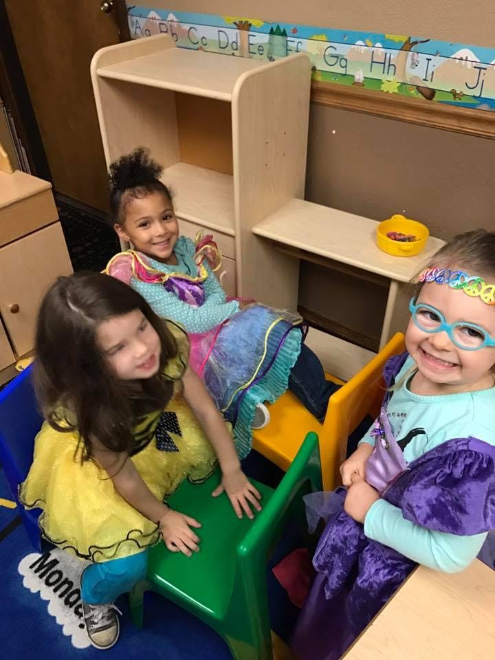 Three children playing in a classroom