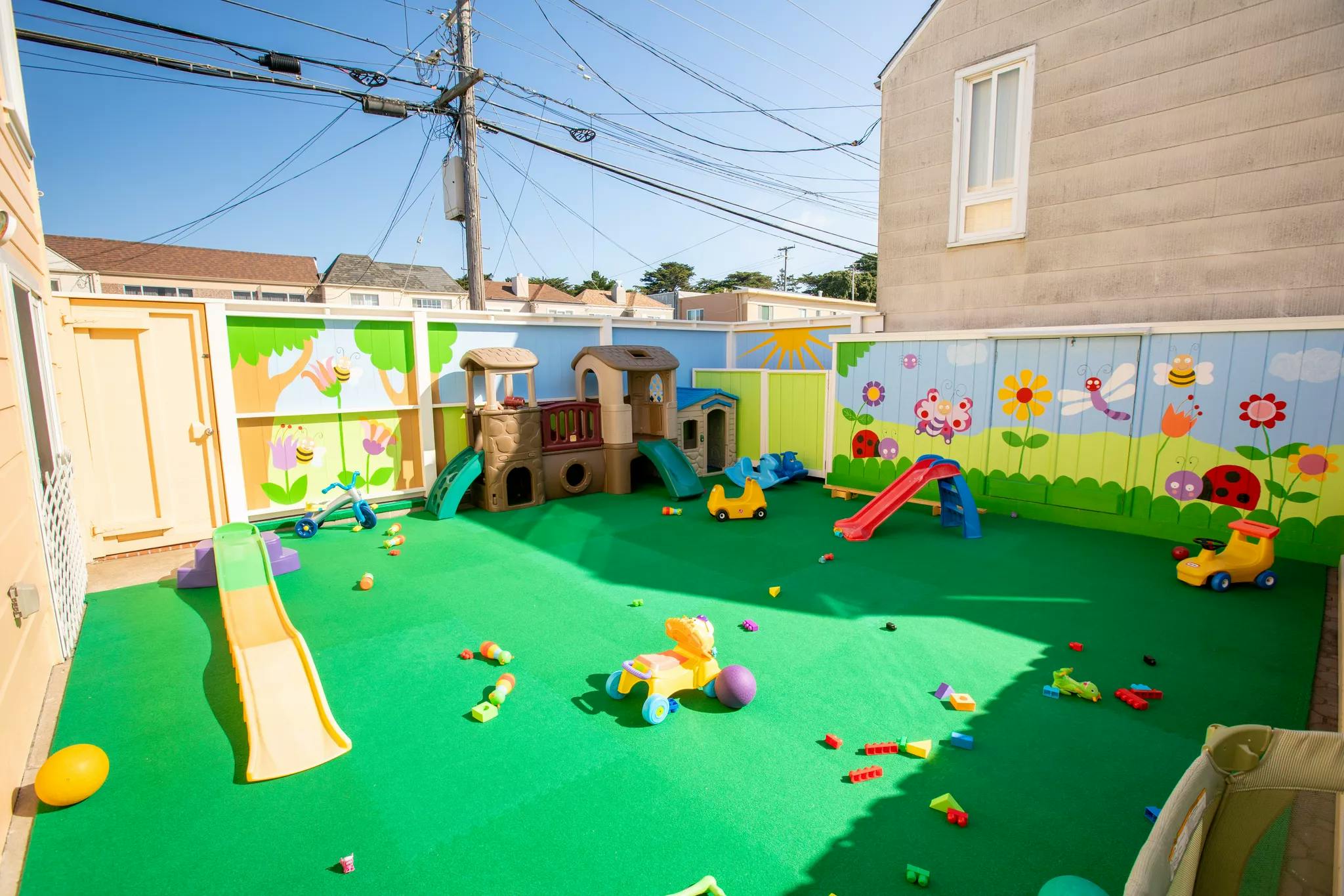 Outdoor playground with green turf, slides, and play structures