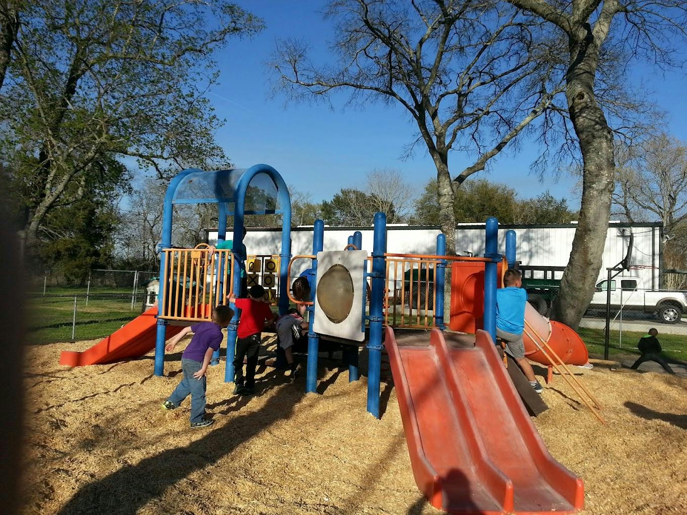 Children playing on a playground structure with slides