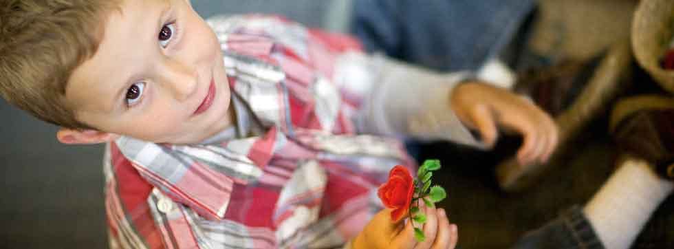 Child holding a red flower