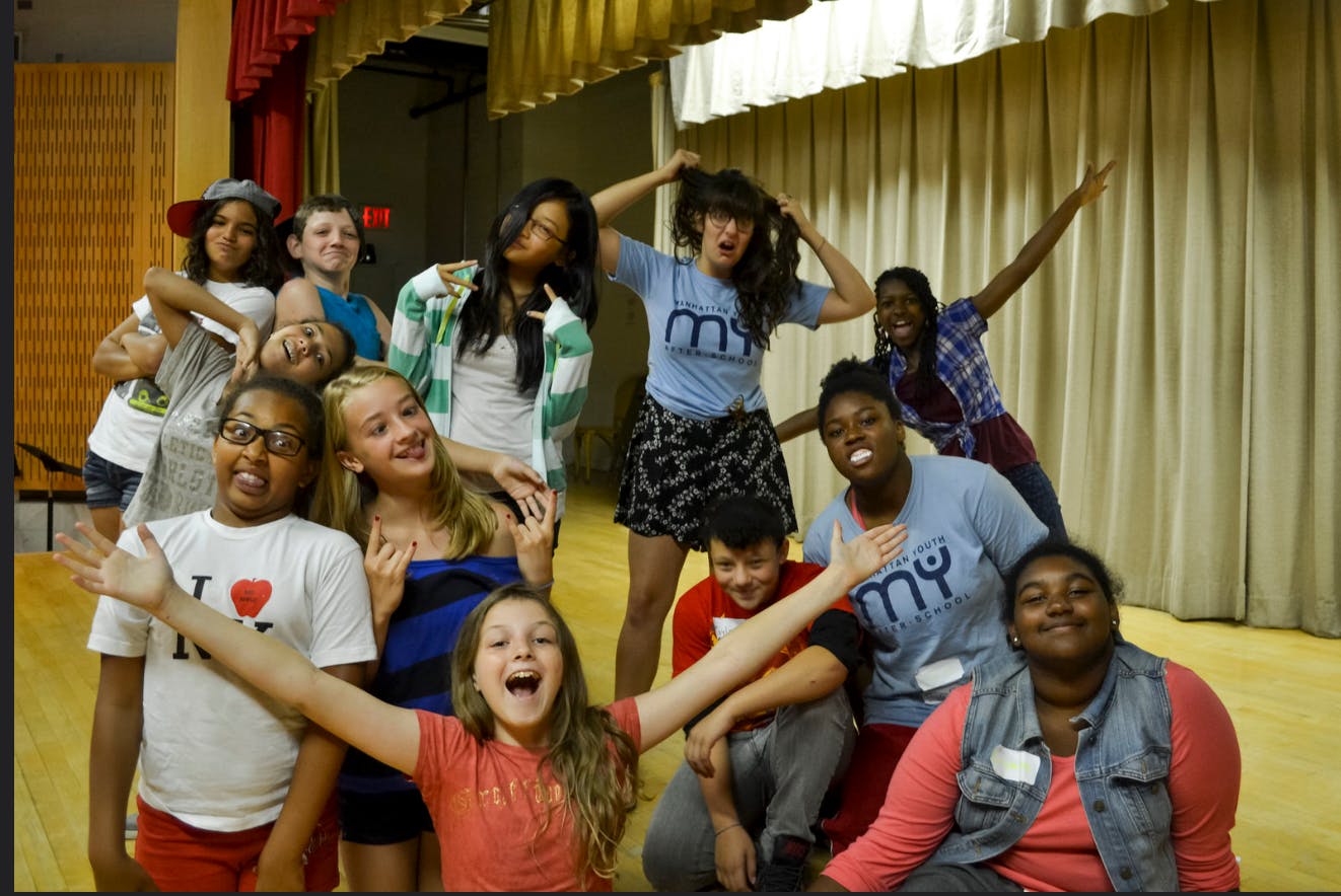 Group of teens posing together on a stage
