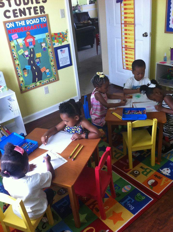 Children drawing and coloring at small tables in a classroom