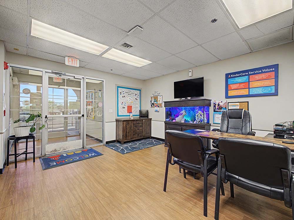 Reception area with a desk and chairs, an aquarium, and a welcome mat