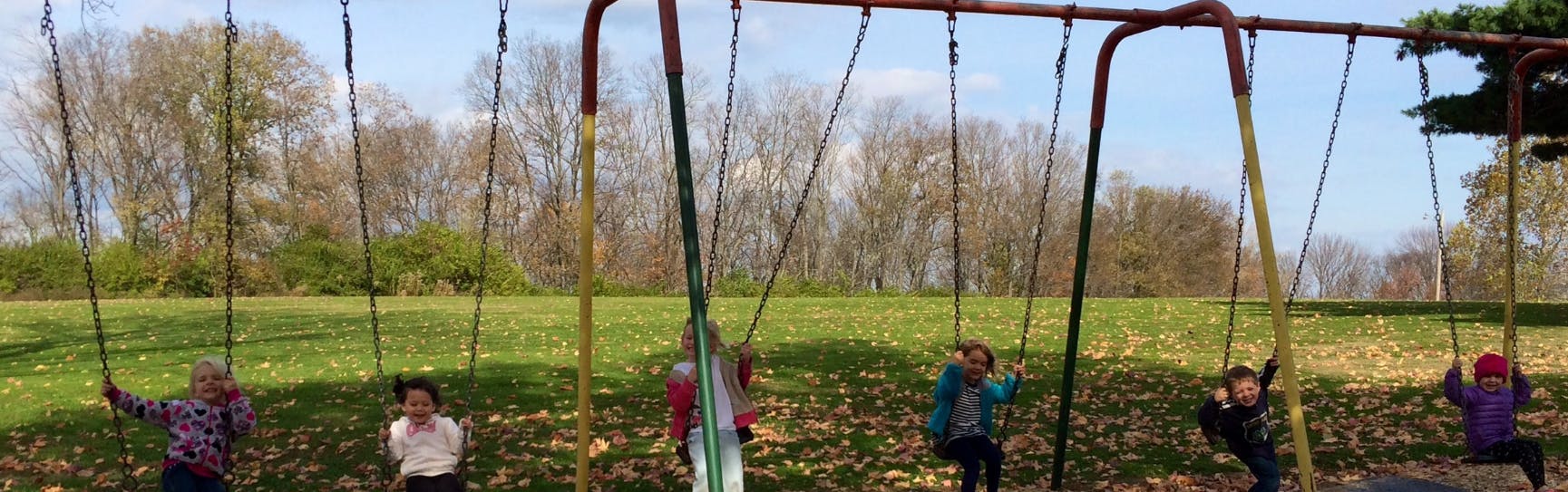 Multiple people on swings at a playground