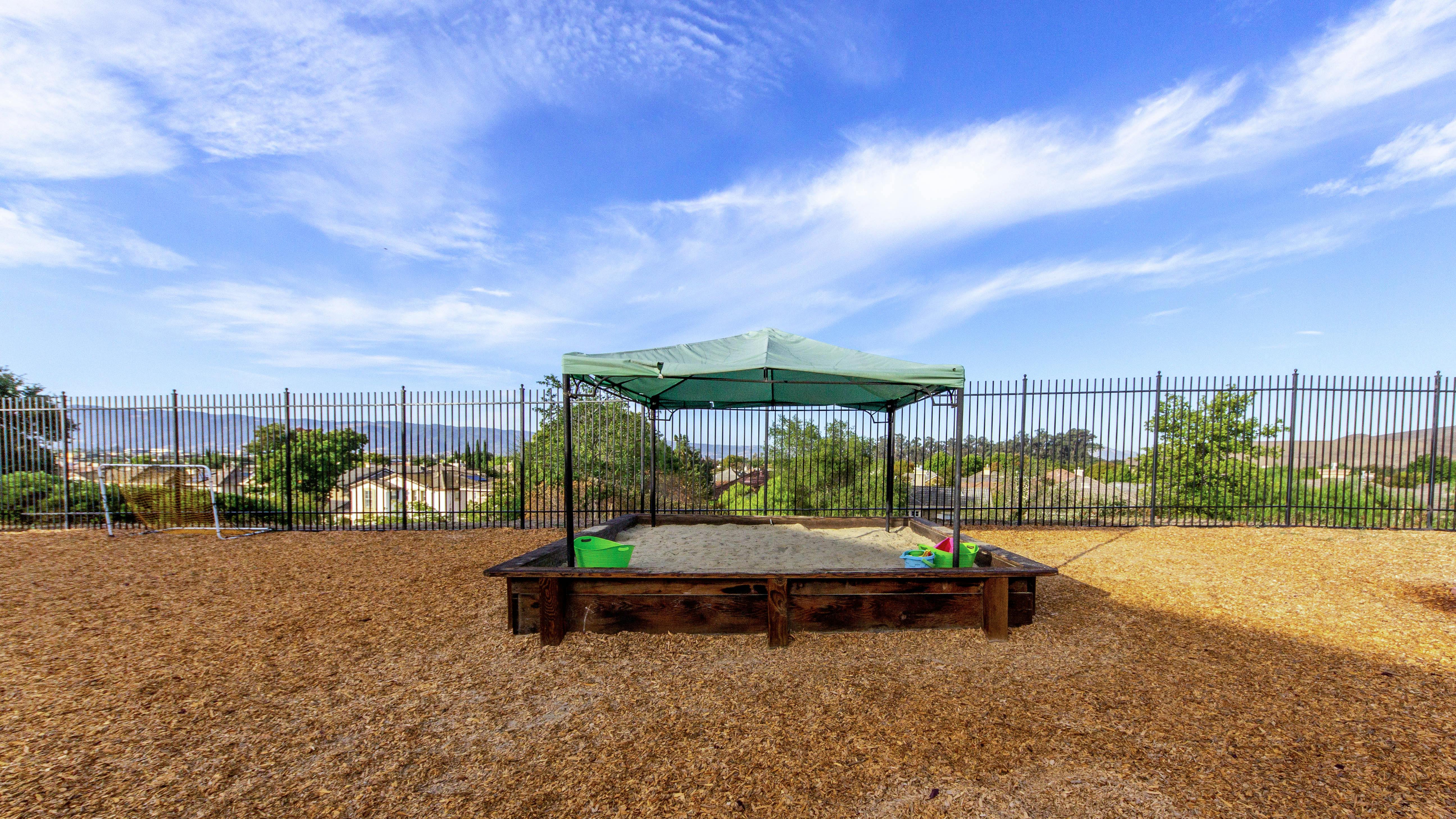 Sandbox with a green canopy