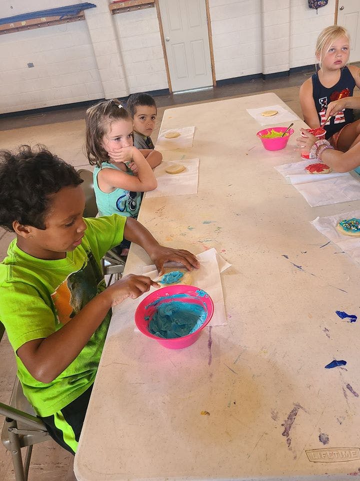 Children decorating cookies at a table
