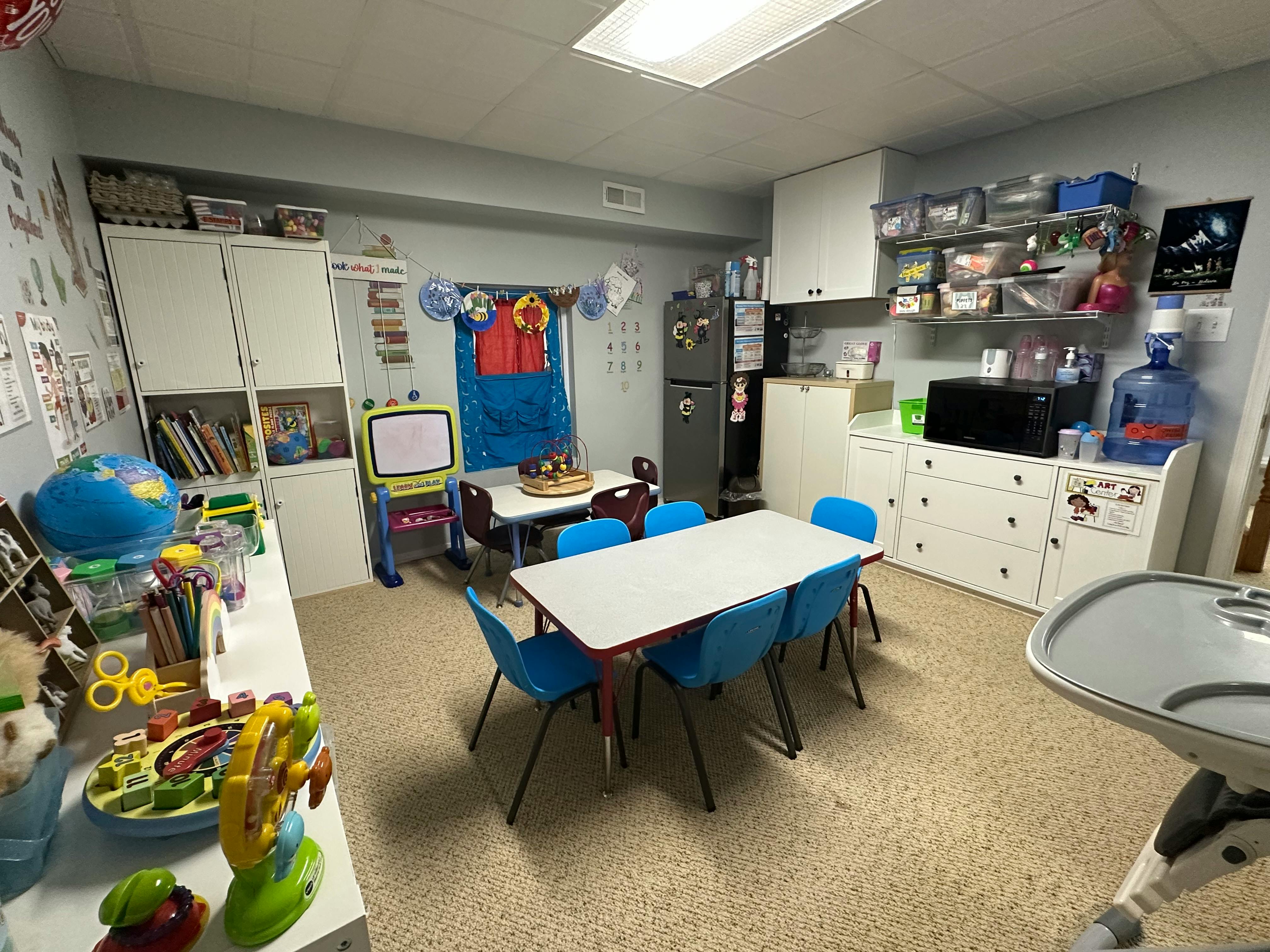 Classroom with tables, chairs, and storage cabinets