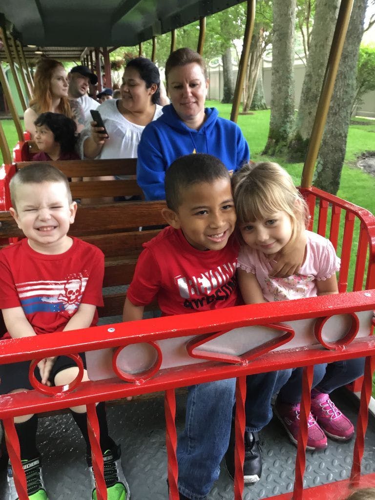 Children and adults riding in a train car