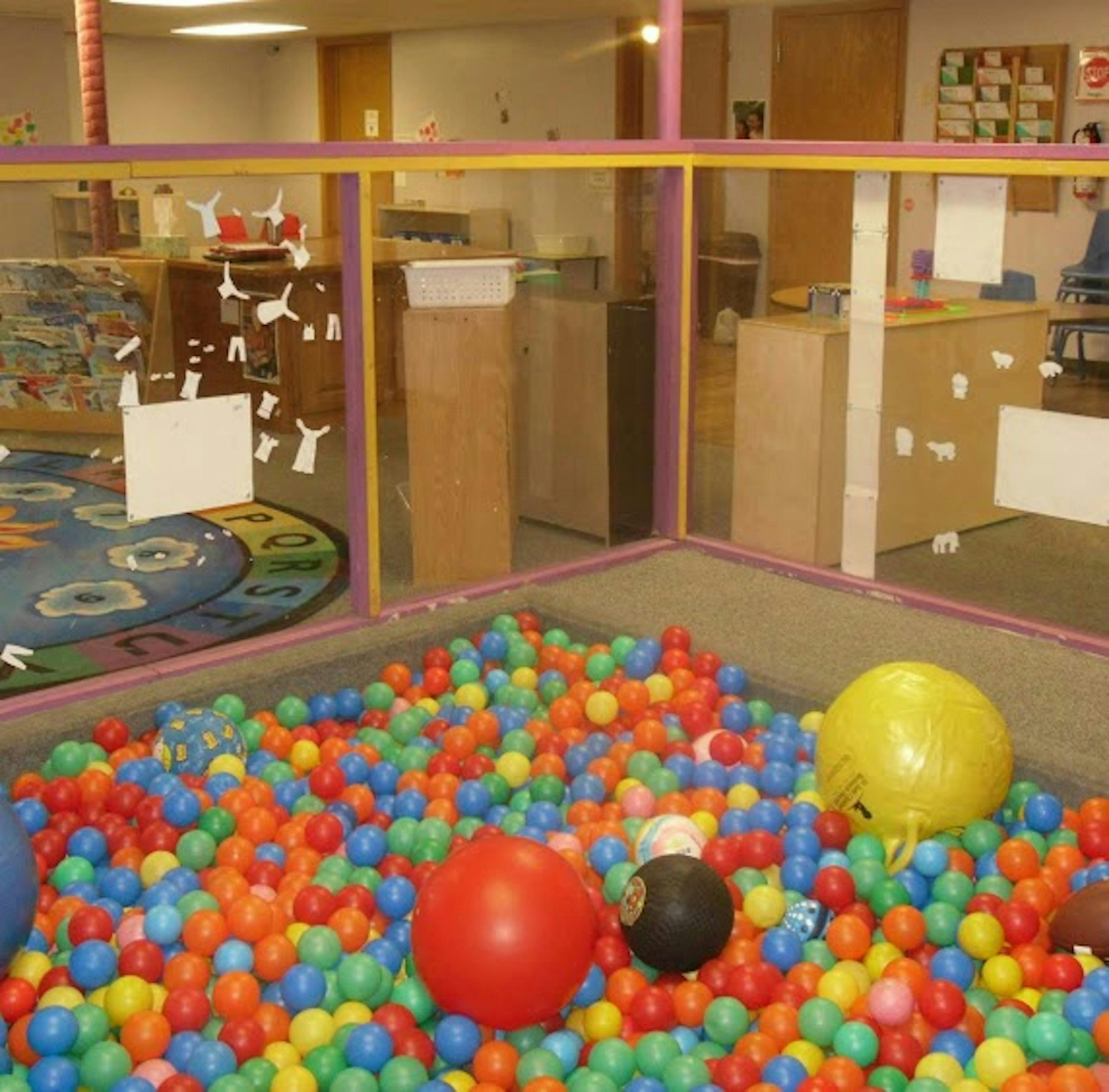 Ball pit with colorful plastic balls and a few larger balls