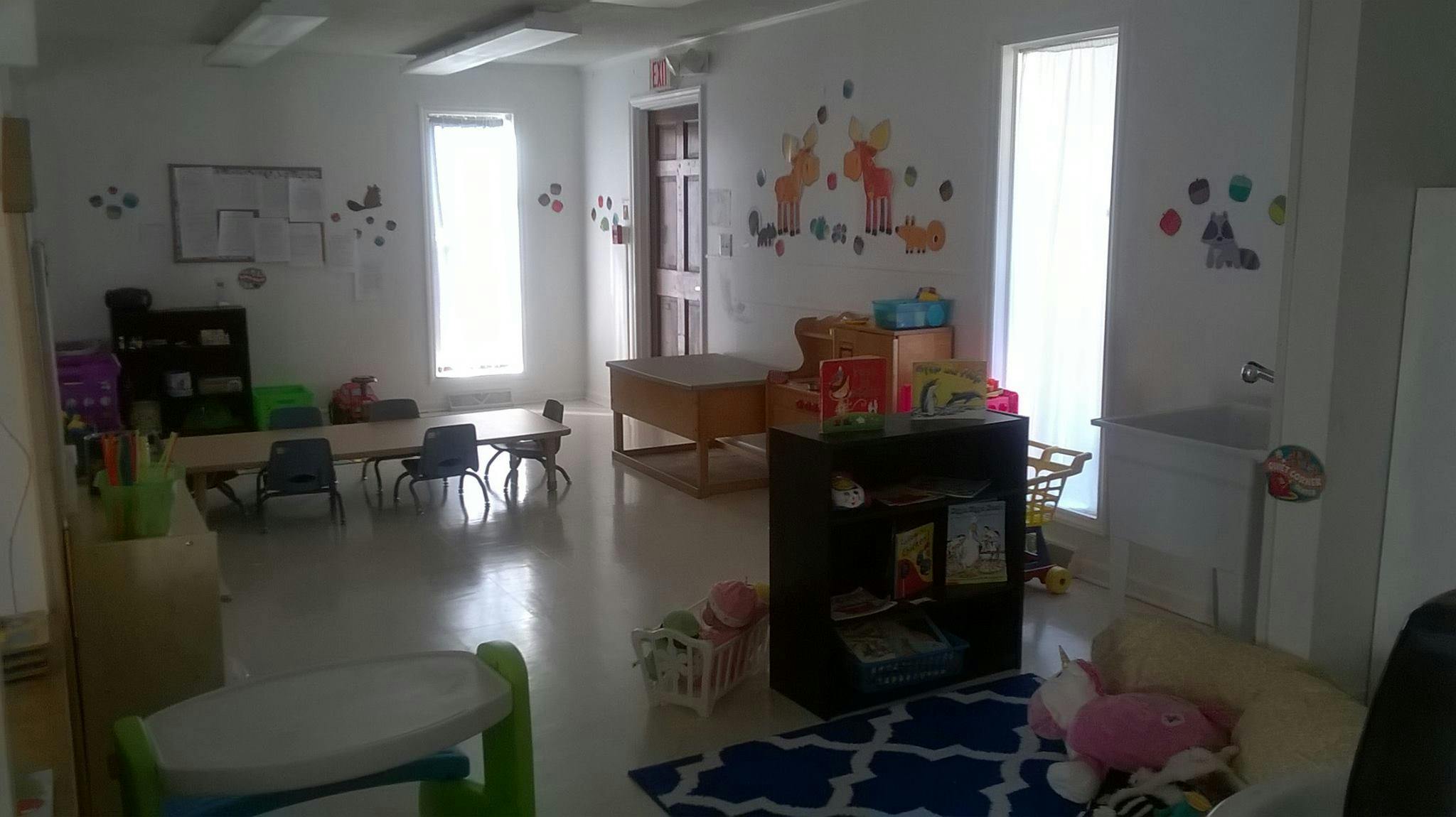Playroom with small tables and chairs, toys, and wall decorations