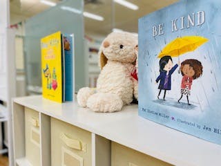 Stuffed animal and children's books on a shelf