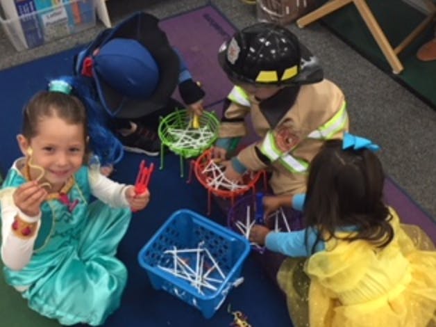 Children playing with colorful baskets and white sticks