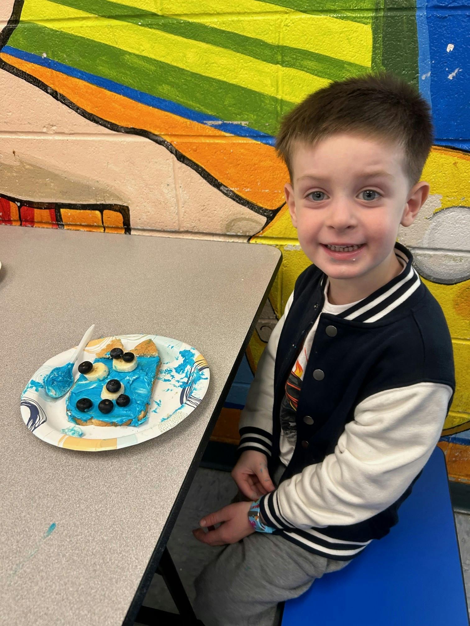 Child sitting at a table with a plate of food decorated toast