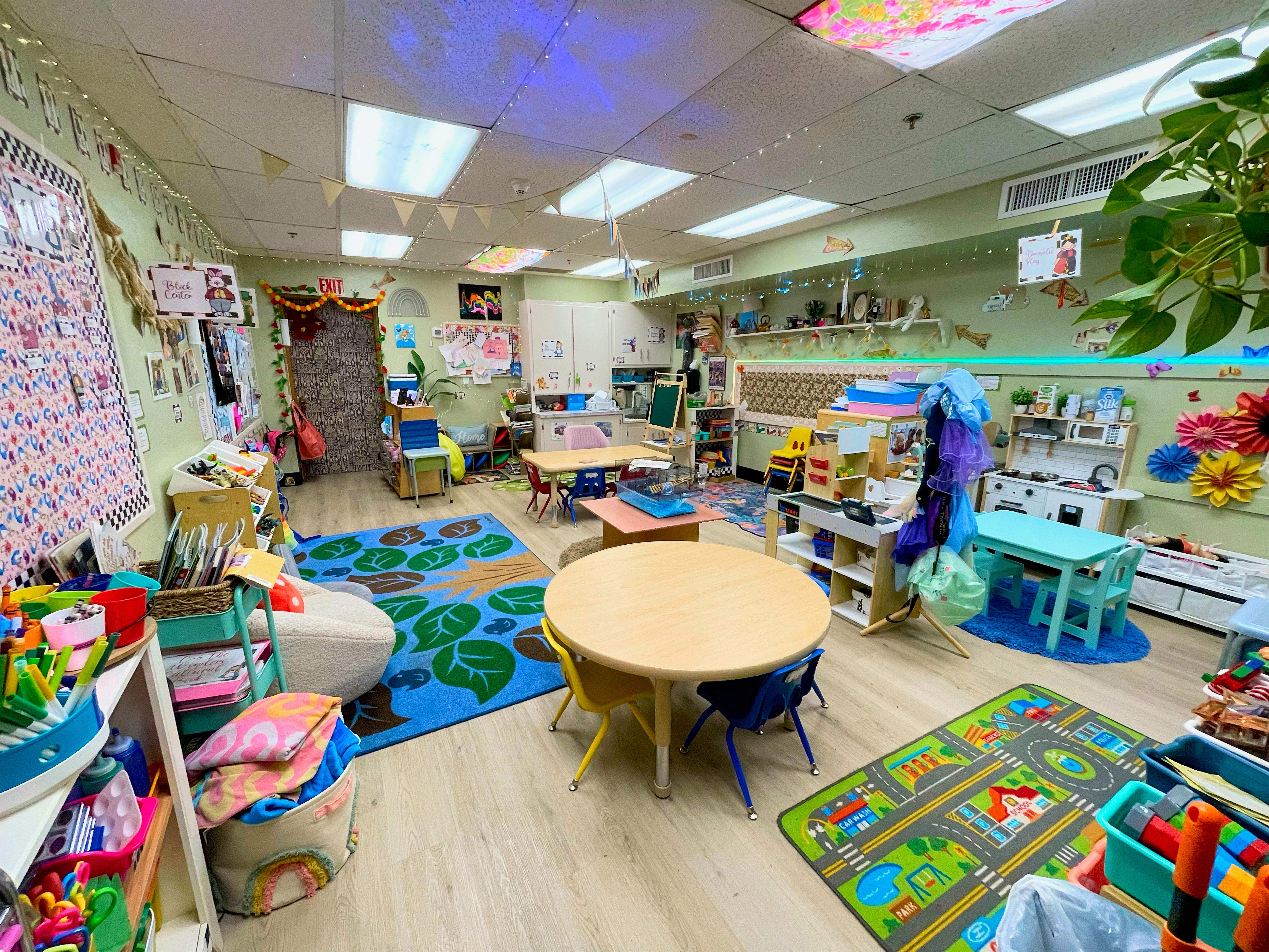 Classroom with small tables, chairs, and colorful rugs