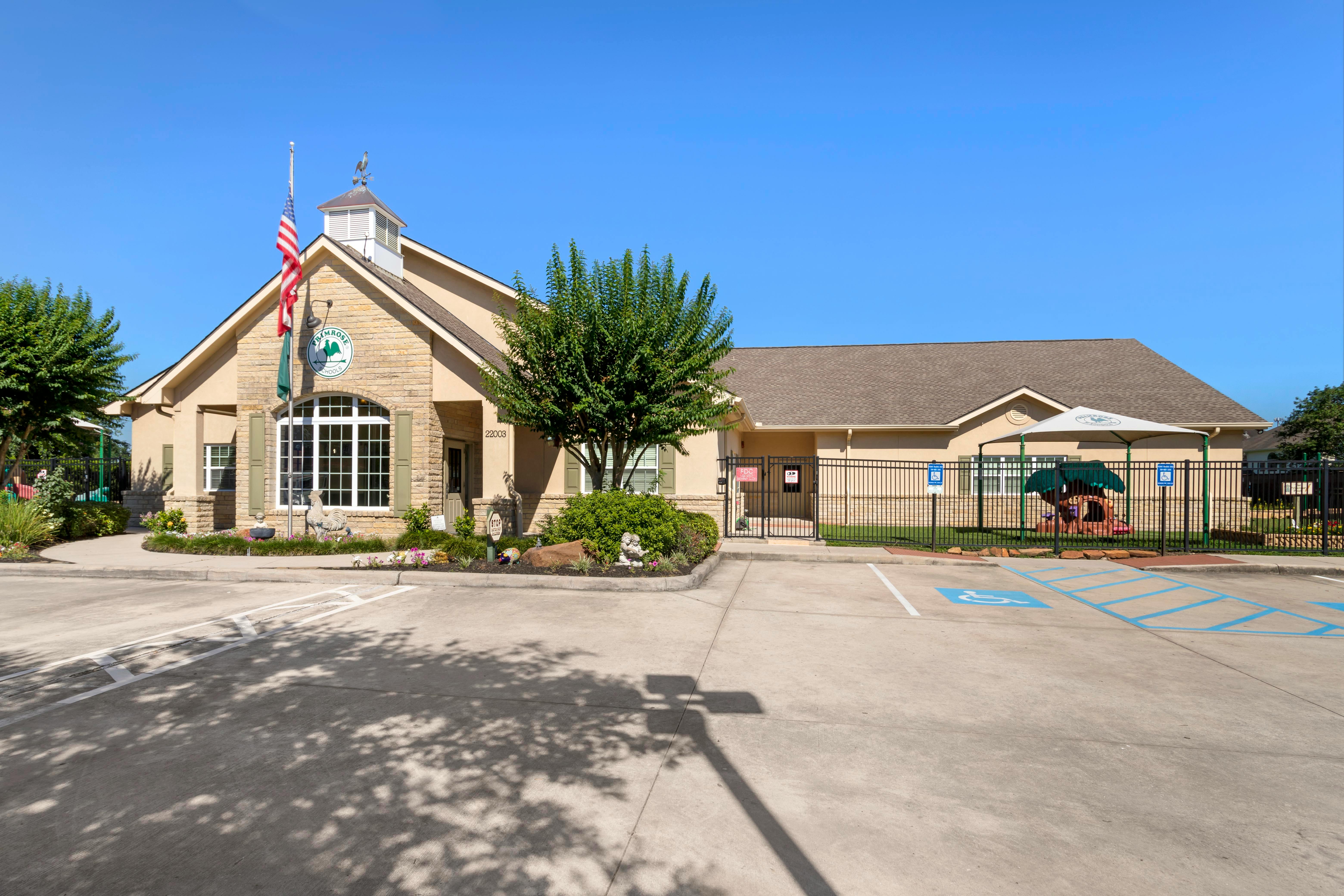 Front exterior of a single-story building with a flagpole and playground area