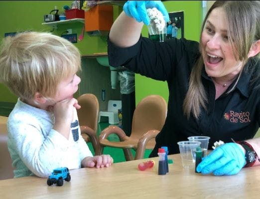 Adult and child doing a science experiment with liquids and cotton