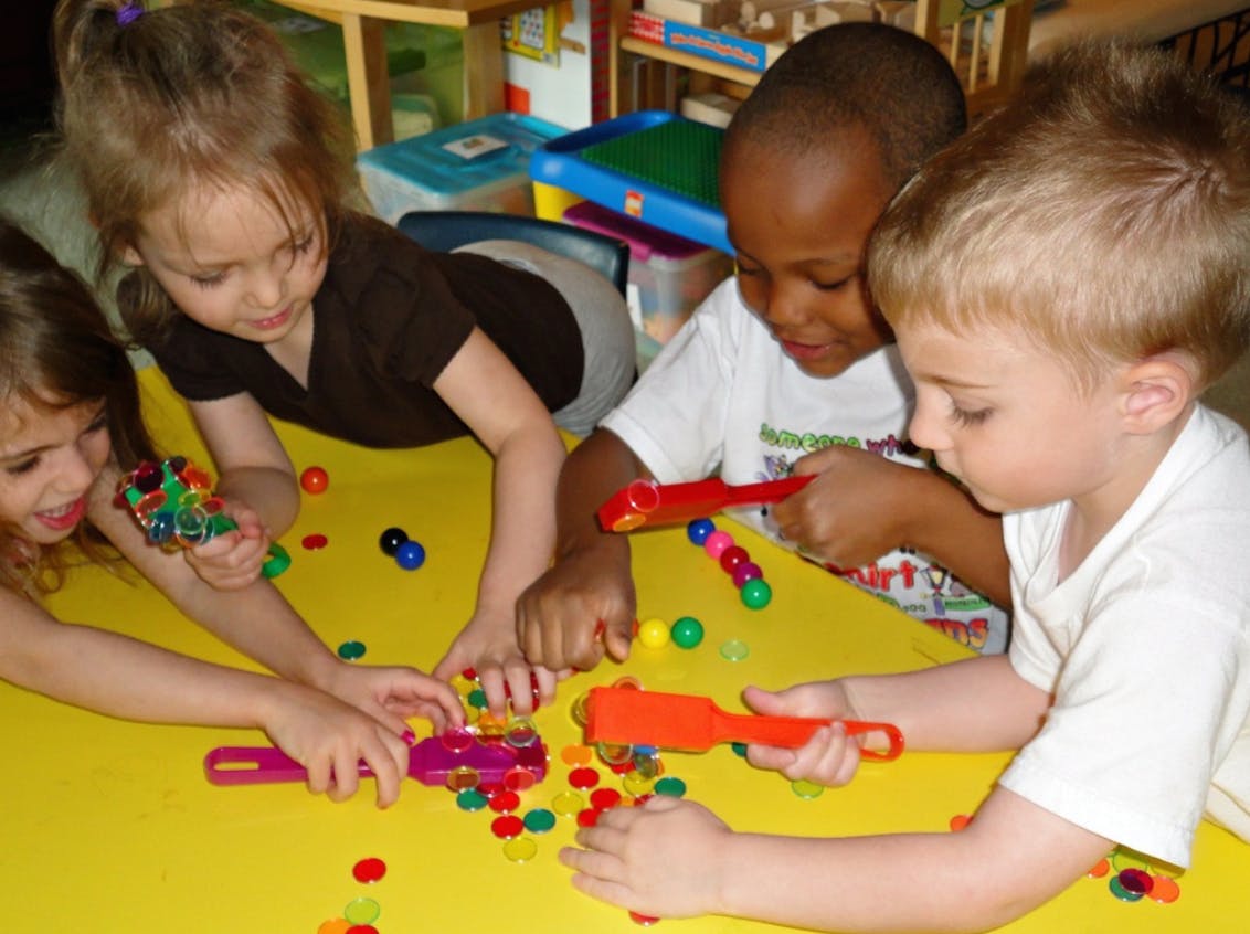 Children playing with colorful magnetic beads and wands