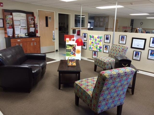 Lobby area with a dark leather sofa, two patterned chairs, and a coffee table