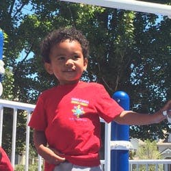 Child in a red shirt on a playground structure