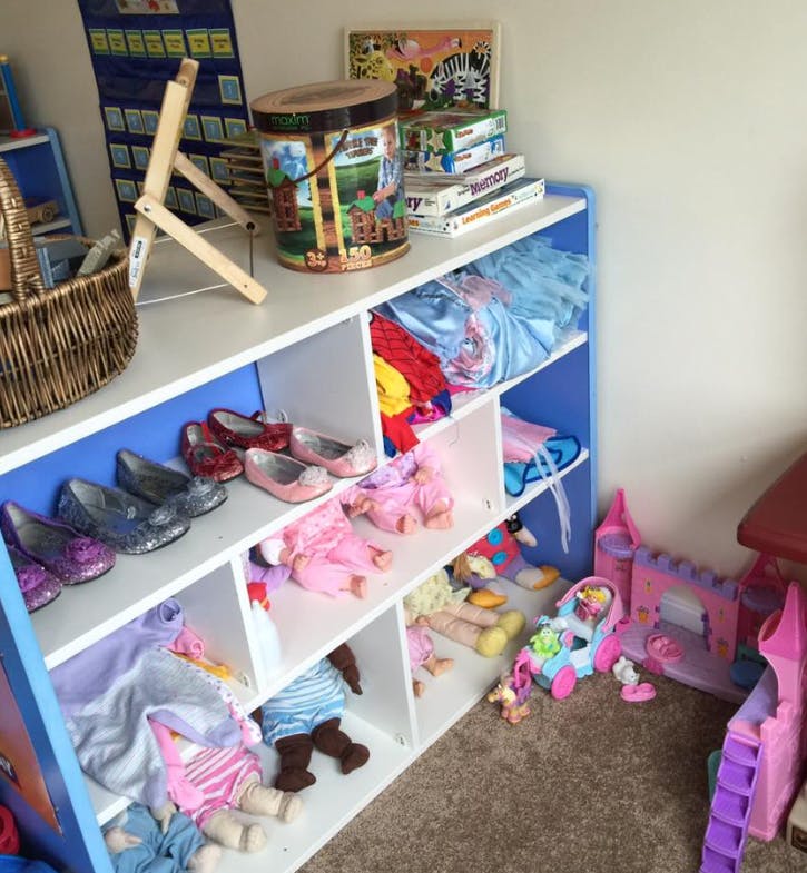 Shelves filled with toys, dolls, and dress-up shoes