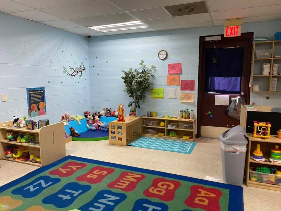 Playroom with alphabet rug, toy shelves, and a reading nook
