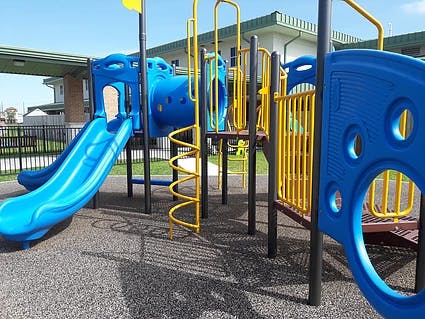 Blue and yellow playground equipment with slides and climbing structures