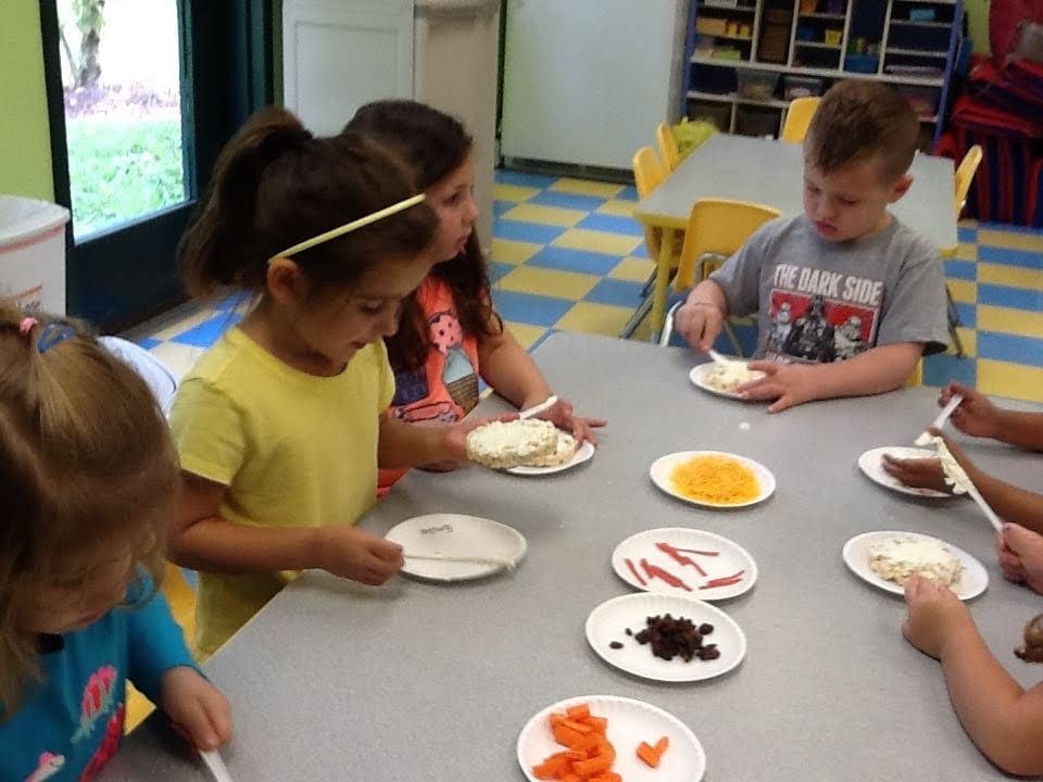 Children decorating food at a table