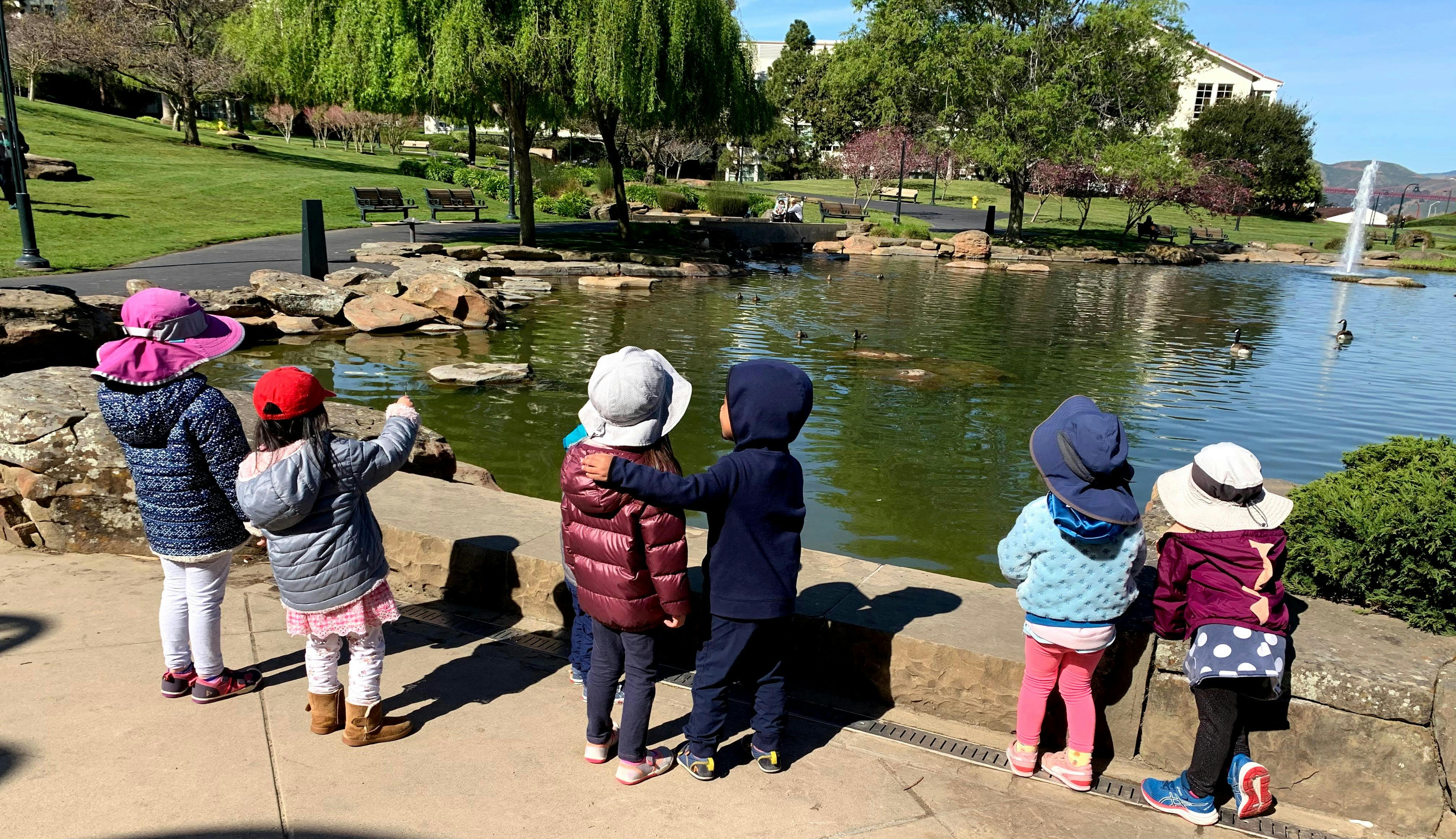 Children standing by a pond