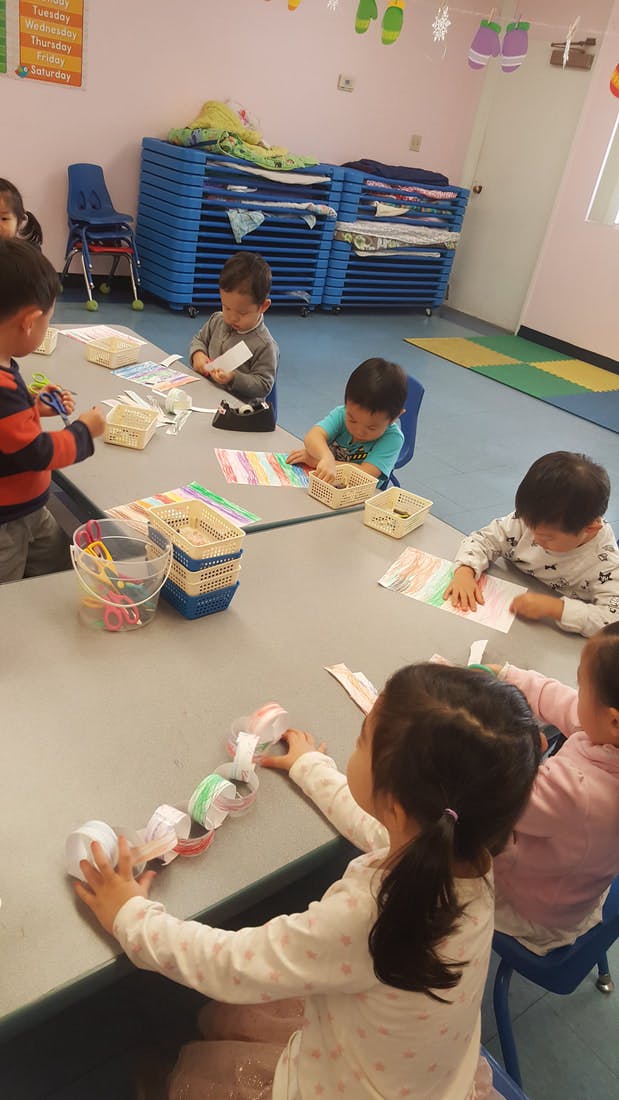 Children sitting at a table doing crafts in-class activities