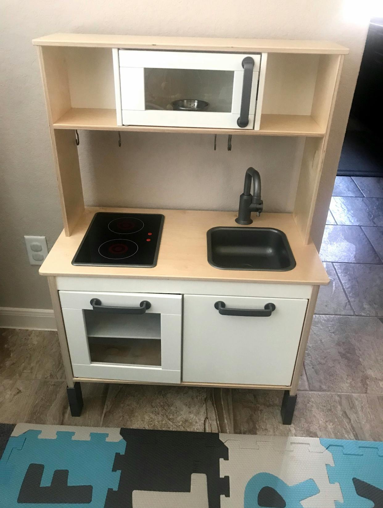 Toy kitchen with microwave, stovetop, and sink