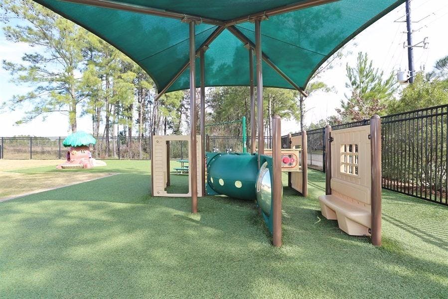 Playground with green turf and a shade structure