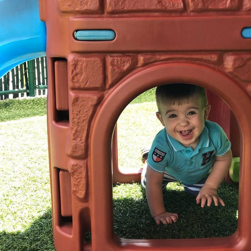 Child crawling through an opening in a play structure