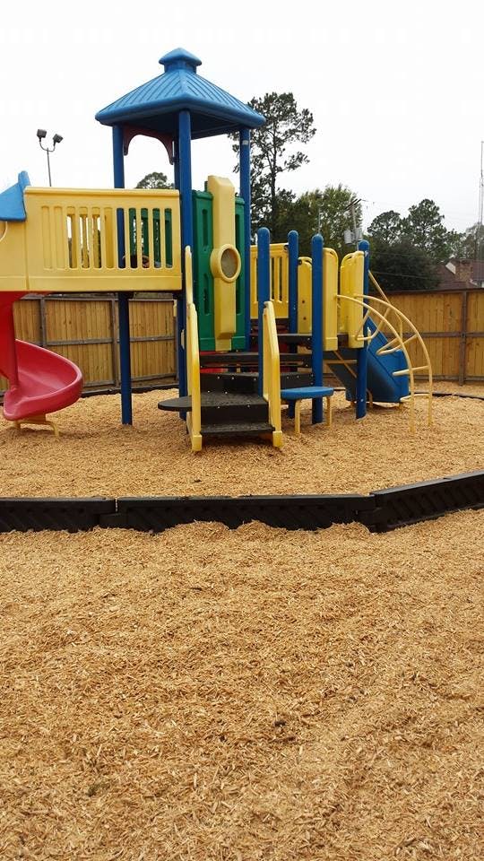 Playground with slides, climbing structures, and wood chip ground cover