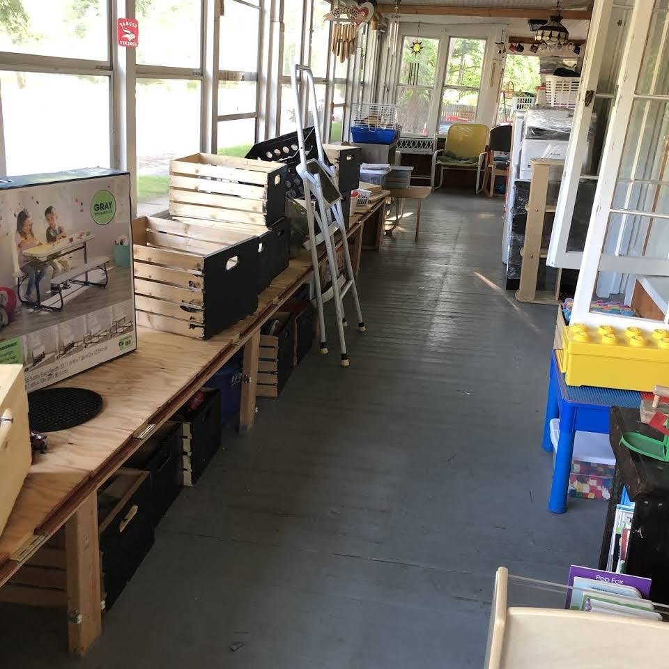 Sunroom with boxes, crates, and a stepladder