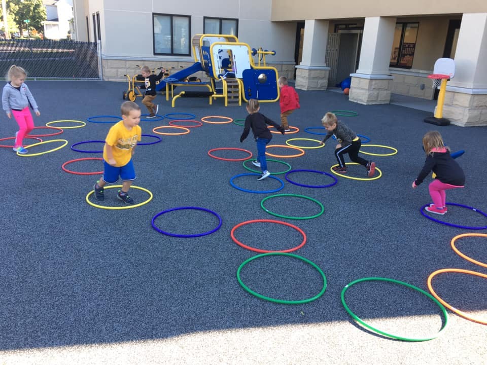 Children playing with hula hoops on a playground