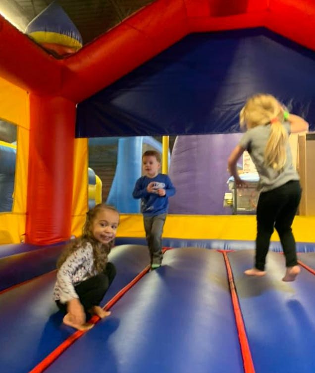 Three children playing in an inflatable bounce house