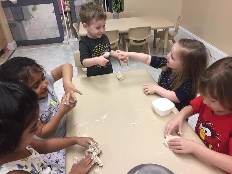 Children playing with dough at a table