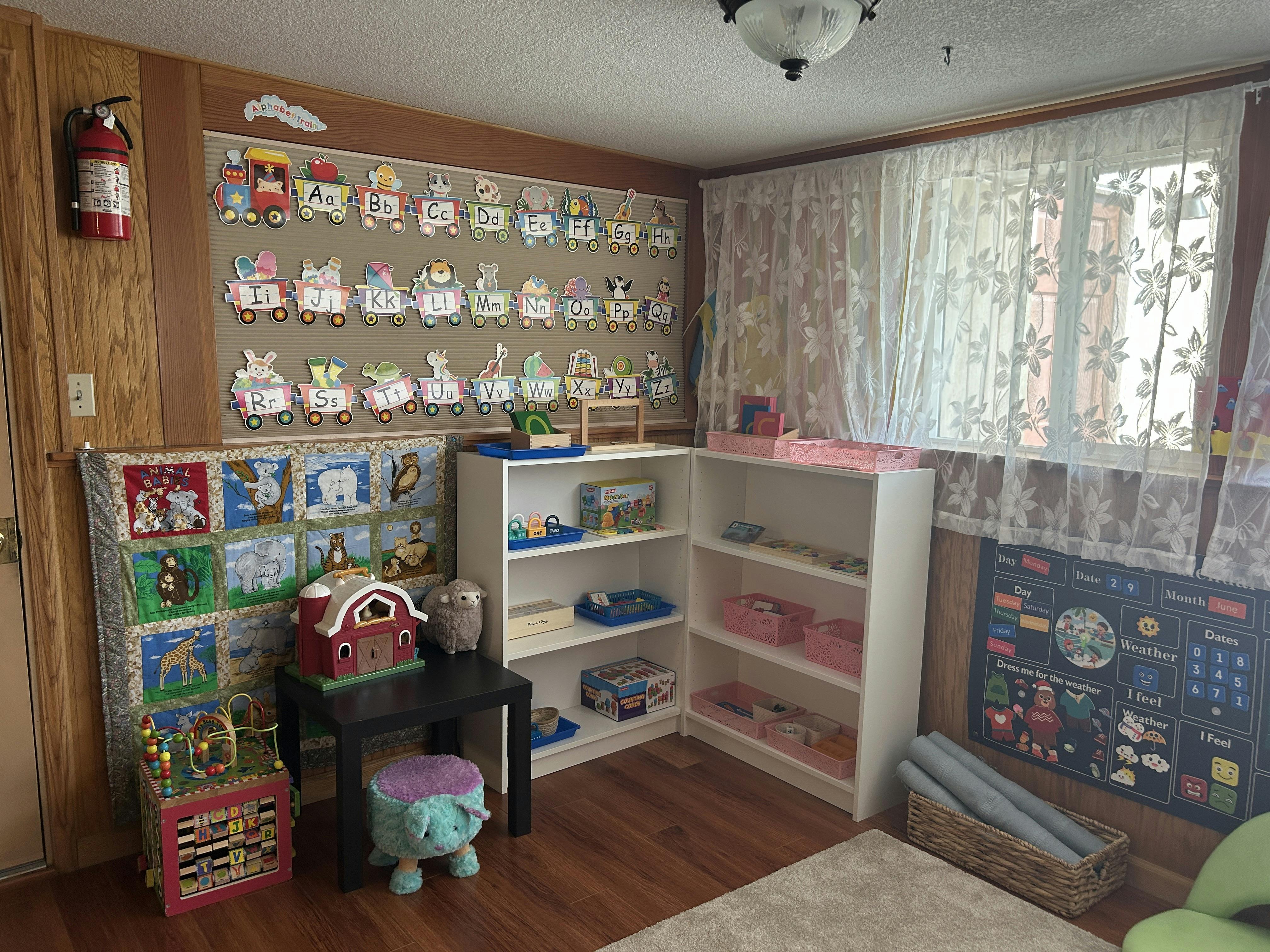 Classroom with educational wall displays, children's toys, and shelves