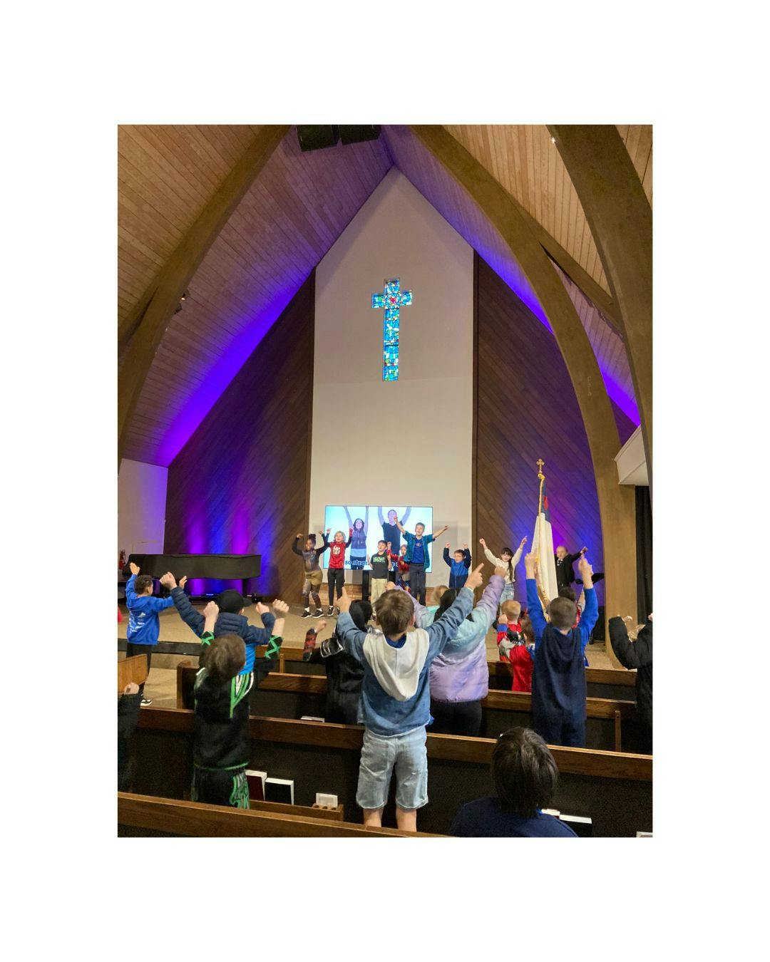 Children with arms raised in a church