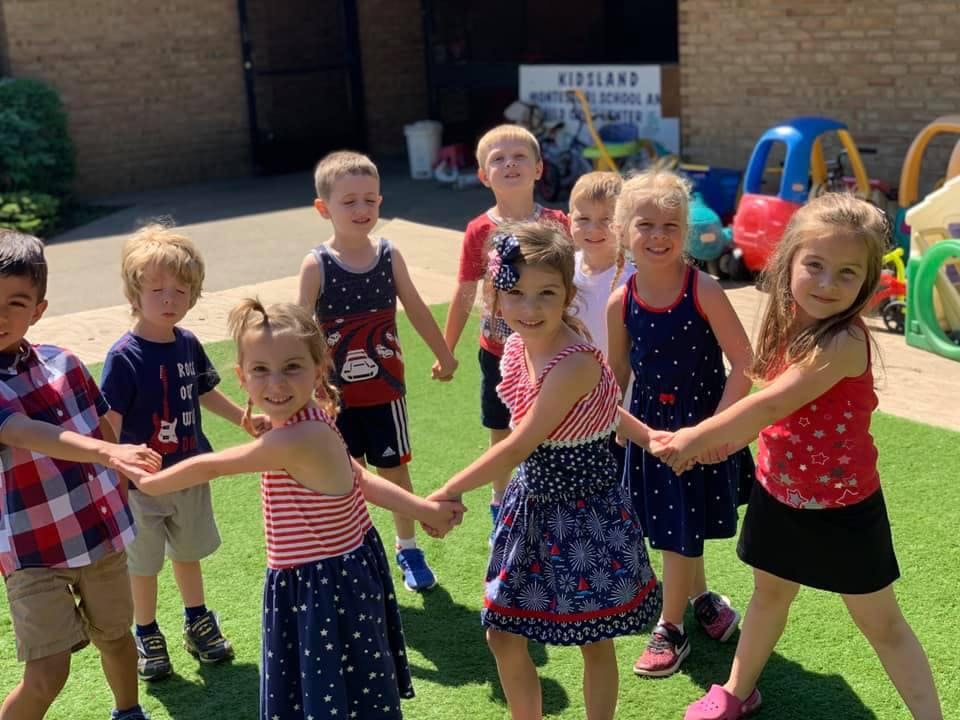 Group of children holding hands in a circle on grass