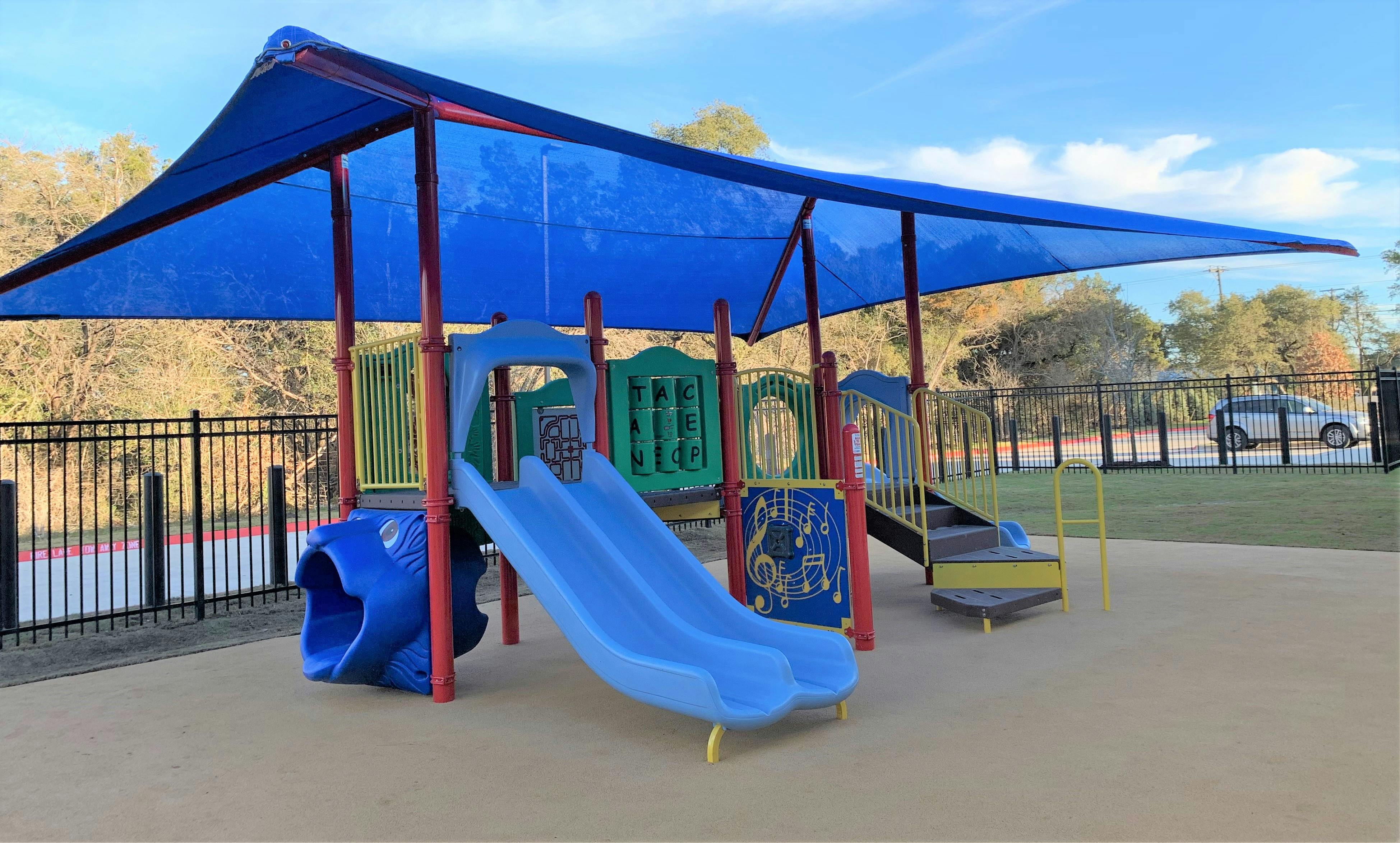Playground with blue slides and a blue shade canopy