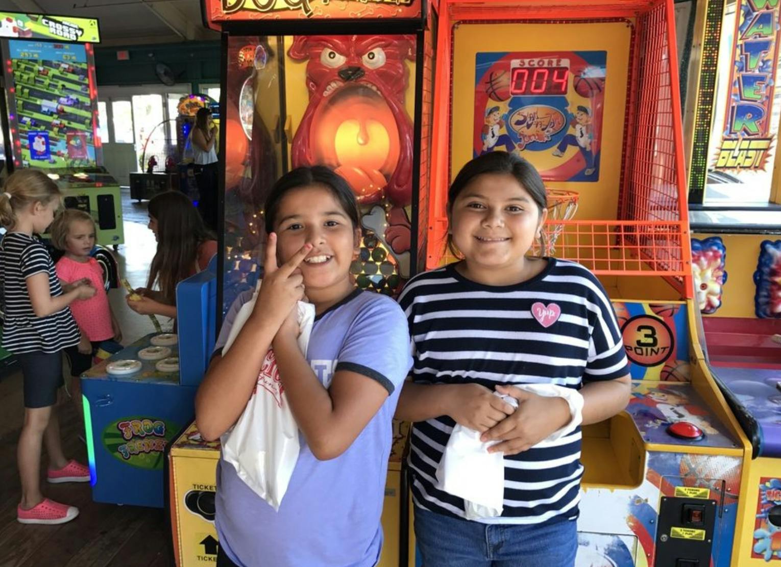 Two children standing in front of arcade games