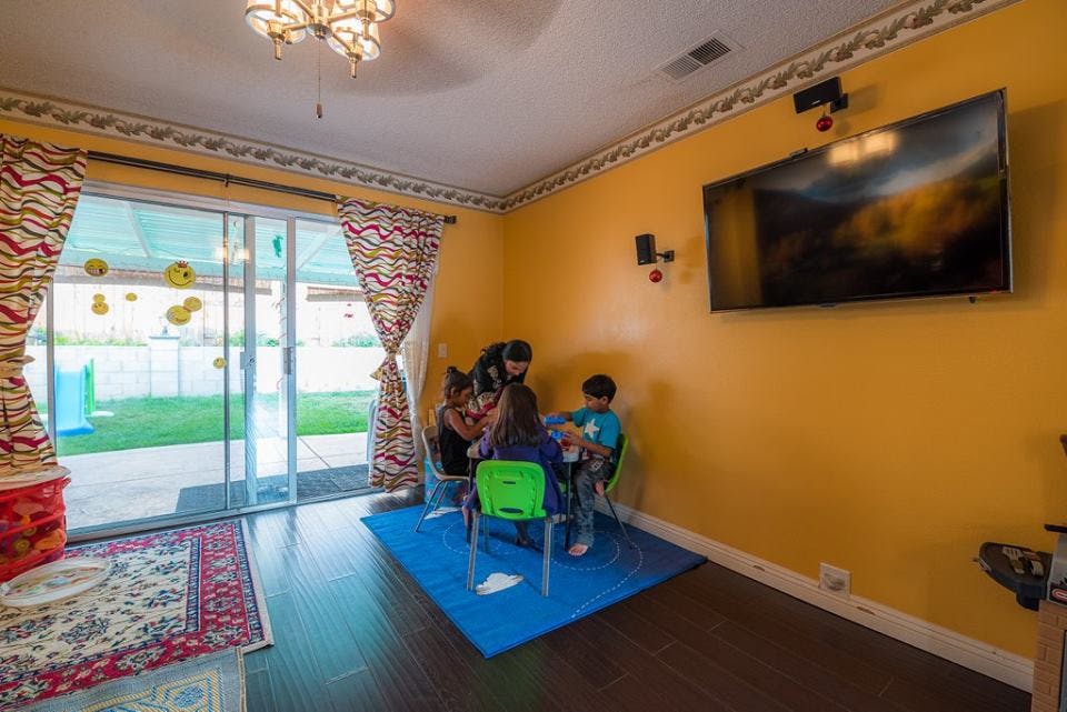 Adults and children sitting at a table in a room