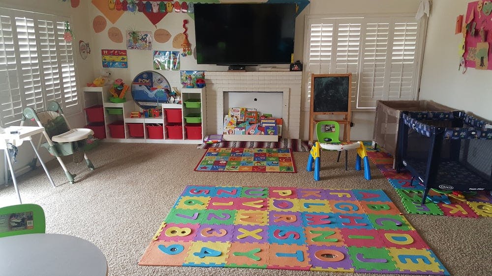 Playroom with colorful alphabet mat, crib, and high chair