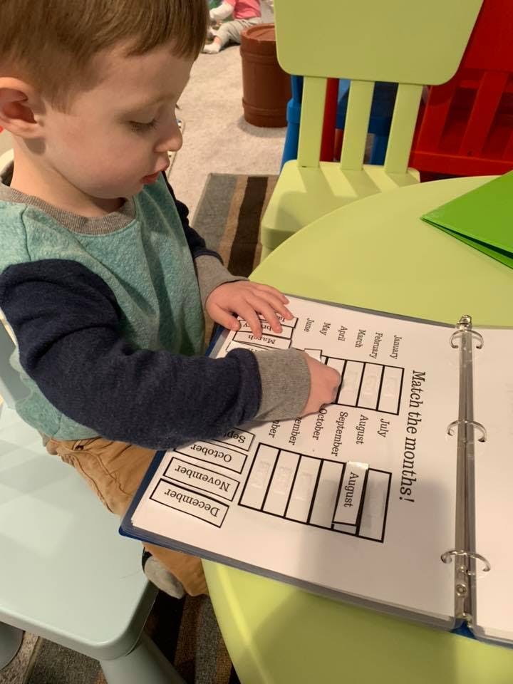 Child matching months on a worksheet in a binder