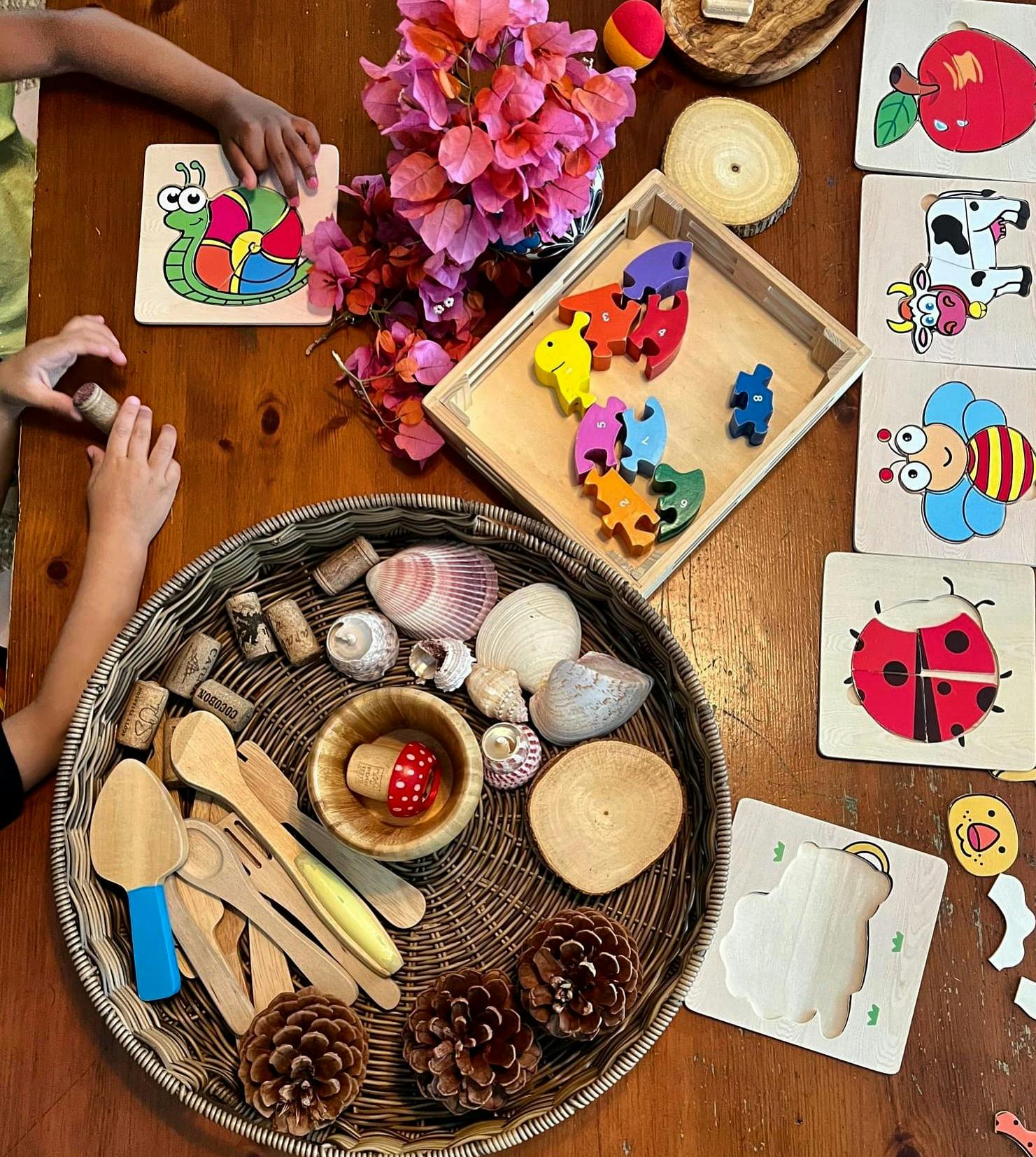Child's hands playing with puzzles and natural elements on a table